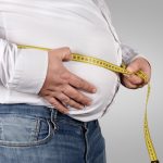 Overweight Man Measuring His Belly with tape measure