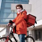 delivery-man-wearing-a-face-mask-and-riding-a-bicycle-4392039