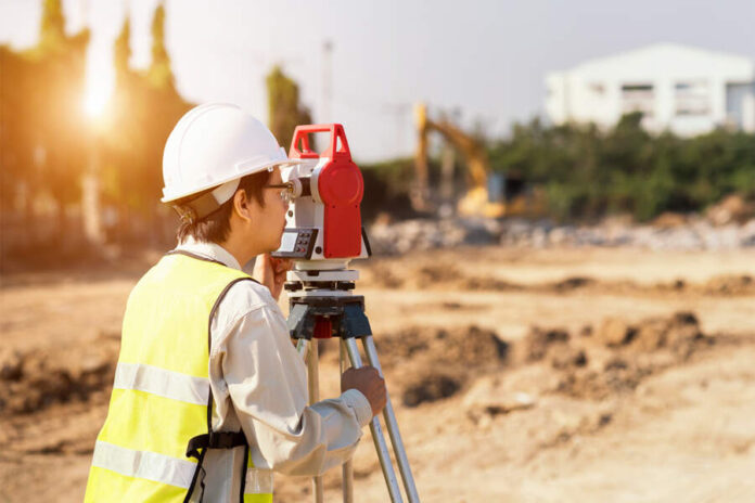 Surveyor engineer is measuring level on construction site. Surve